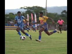 Credit: Ashley Anguin The Manning’s School’s Keandre Ellis (left) and Clarendon College’s Lashaun Harris compete for the ball during their ISSA/Mighty Malt rural under-16 football final at the St Elizabeth Technical High School yesterday. Manning’s won 3-2.
