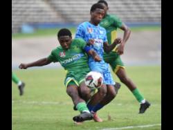 Devone Davis (centre), while representing McGrath High School, is tackled by Ashawn Harris (front) of Ocho Rios High School during their ISSA WATA daCosta Cup semi-final at the National Stadium. Davis scored a hat-trick for Molynes United FC in their 5-1 Jamaica Premier League win against Vere Phoenix on Sunday.
