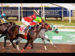 Fast finishing MAGNIFICENT FORCE (No.11), ridden by Ian Spence, winning the ninth race over 5 1/2 furlongs ahead of MIDNIGHT FLIGHT (Shane Ellis) against the rails at Caymanas Park on Saturday.