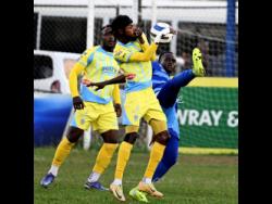 Waterhouse FC’s Denardo Thomas takes evasive action as Molynes United’s Mikel Graham attempts to kick the ball during the Jamaica Premier League football match at Waterhouse Mini Stadium yesterday. The game ended 1-1.