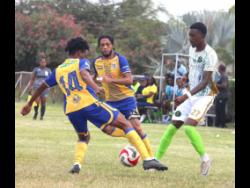 Harbour View’s Trey Bennett (left) and teammate Rohan Brown (centre) attempt to get the better of  Vere Phoenix’s Damoi Whitfield during their Jamaica Premier League football encounter at the Wembley Centre of  Excellence in Clarendon yesterday. The game ended 1-1.