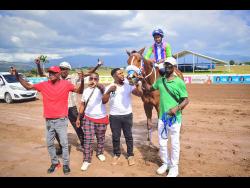 GENERATIONAL with champion jockey Raddesh Roman in the saddle, parades with connections after winning the fourth race over 5 1/2 furlongs at Caymanas Park on Saturday.