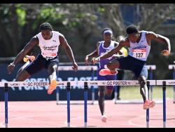 Jamaica College’s Princewell Martin (left) wins the Boys’  Under-20 400m hurdles at the Carifta Trials at G.C. Foster College yesterday in 50.84 seconds. At right is Theo Morgan who  hit a hurdle and did not finish the race.