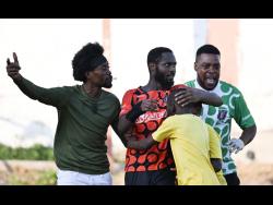 Tivoli’s Lennox Russell (centre) gets congratulations from two fans after he scored the third goal to earn his team a come from behind 3-2 win in the Jamaica Premier League match at the Edward Seaga Sports Complex in Tivoli Gardens yesterday.