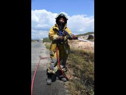 Firefighter Shanieke McKoy on duty along the Hellshire main road in St Catherine.