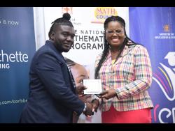 Sean Fagbola (left), math teacher at Esher Primary School, receives his award for being the top math teacher for Region 4 at the Mathematics Teacher of the Year awards yesterday at the Caenwood Centre in Kingston. 