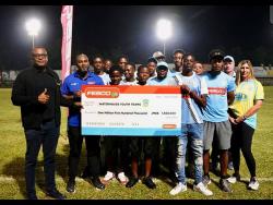 Jeremy Barnes (left), Fesco’s director and CEO, and Stefan Ebanks (second left), head of Business Development, Sales, Marketing and Communications, present their sponsorship commitment of $1.5 million to members of Waterhouse Football Club’s youth teams and management. Also present are club director Nicola Bicknell (right), Chairman Bruce Bicknell (second right, partly hidden) and Damoney Kildare, coach of the Under-13 and Under-15 teams.