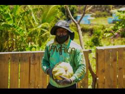 Credit: Matthew McKoy Kevon Watt proudly shows off one of his pumpkins grown in the heart of Rockfort, East Kingston.