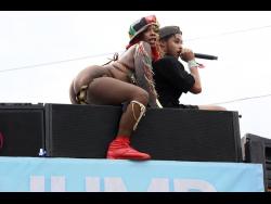 Dancehall artiste Pamputtae (left) and a DJ atop a Yardmas truck during Carnival Road March on Sunday.