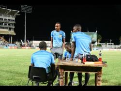 Match officials in the Jamaica Premier League football quarter-final football game between Tivoli Gardens and Montego Bay United converge along the sideline after the game was stopped due to inadequate lighting at Sabina Park on Thursday night.