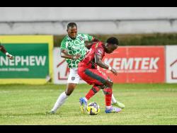 Johann Weatherly (right) of Montego Bay United FC shields the ball from Shaquille Jones of Tivoli Gardens FC during their Jamaica Premier League quarter-final football match at Sabina Park on Monday. The game ended 1-1, but MoBay United advanced 2-1 on aggregate.