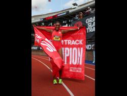 Ackera Nugent holds aloft the Grand Slam Track flag after cementing her second title at the Franklin Field stadium in Pennsylvania yesterday.