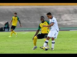 Credit: Matthew McKoy Jamaica’s two-goal hero Warner Brown positions himself to challenge Guatemala’s Jose Ardon for the ball during their Concacaf World Cup Qualifying football match at the National Stadium in Kingston on Tuesday. Jamaica won 3-0.