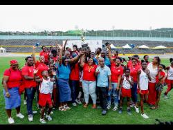 Members of the St Catherine team lift the winning trophy for the 2025 JTA/Sagicor National Athletics Championship at the National Stadium on Saturday.