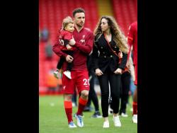Liverpool’s Diogo Jota walks the pitch with his family after the English Premier League match at Anfield, Liverpool, on Sunday May 22, 2022.