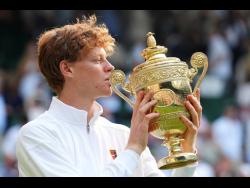 Jannik Sinner of Italy holds the trophy after winning the men’s singles final match against Carlos Alcaraz of Spain at the Wimbledon Tennis Championships in London yesterday.