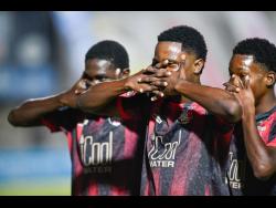 From left: Arnett Gardens’ Rushane Thompson celebrates a goal against Molynes United with teammates Ricardo Thomas and Kivann Salmon at the Waterhouse Stadium in March.