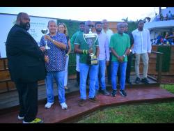 Supreme Ventures Racing and Entertainment Limited (SVREL) Chairman Solomon Sharpe (left) presents winning trainer Jason DaCosta with his trophy during the presentation ceremony for the Jamaica Derby, which was won by his charge I DREAM AGAIN, at Caymanas Park yesterday. Other members of the winning connections for the Derrick Smith-owned horse look on.