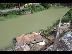 The derailed cars from the bauxite train that nearly ended up fully in the Rio Cobre.