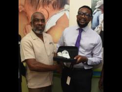 Credit: Ian Allen Len Johnson (left), president of the JURA Foundation, presents a fetal Doppler machine to Dr Garth McDonald, senior medical officer of Victoria Jubilee Hospital, during a handover ceremony of 27 of the machines.