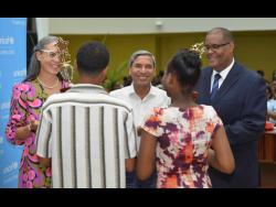 Dr Diana Thorburn (left), chair for the Child Protection and Family Services Agency’s (CPFSA) advisory board; Mohammad Mohiuddin (centre), deputy representative for UNICEF Jamaica; and Newton Douglas, director of policy, planning and evaluation at CPFSA; congratulate the most outstanding boy and girl at the CPFSA’s PEP Awards Ceremony held on Thursday at the Jamaica Conference Centre in Kingston. 