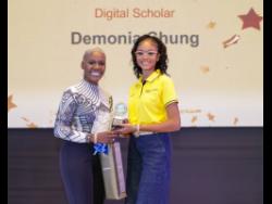 An elated Demonia Chung (right), 2025 digital scholar in N.C.B. Foundation’s Scholarships and Grants programme, collects her award from Sharon Williams, N.C.B. Foundation board director, at the official award ceremony held at the AC Marriott in Kingston recently.