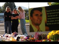 Women pray on Saturday at a memorial outside Utah Valley University after Turning Point USA CEO and co-founder Charlie Kirk was shot and killed in Orem, Utah