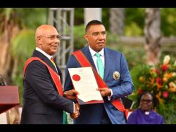 Governor General Sir Patrick Allen (left) hands over the Instrument of Appointment to Prime Minister Dr Andrew Holness at the swearing-in ceremony at King’s House yesterday.