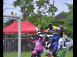 Rusea’s High’s Omarion Jemmison (second right) jumps highest to head the ball into the net during yesterday’s daCosta Cup match against Frome Technical High at the Collin Miller Sports Complex. Lightning and rainfall forced officials to call off the match at  halftime.
