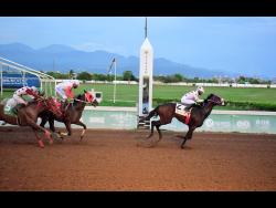 UNSPUN (right), ridden by Reyan Lewis, wins the Typewriter Trophy feature event ahead of INTRESTNTIMESAHEAD (Shane Ellis) and PROVIDENT (left), Phillip Parchment) at Caymanas Park yesterday.