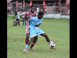 Credit: Ashley Anguin Maldon High’s Clevon Campbell (front) shields the ball from Herbert Morrison Technical High’s Demetri Popkin during their Zone A ISSA daCosta Cup match at Herbert Morrison yesterday.
