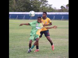 Credit: Ashley Anguin Ocho Rios High’s Shamari Linton (front) shields the ball from York Castle High’s Rushawn Coke during their Zone K ISSA daCosta Cup match at the Drax Hall Sports Complex yesterday.