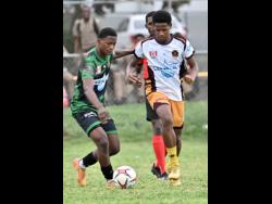 Kimani Thompson (left) of Calabar High looks to play the ball while coming under pressure from Jordan Brown of Wolmer’s Boys’ School during the ISSA WATA Manning Cup football match at Wolmer’s Boys’ School on Tuesday. Calabar won 2-1.