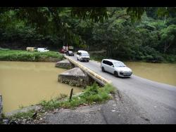 Credit: Ian Allen Motorists navigate the Flat Bridge in the Bog Walk Gorge. Residents are anticipating the Rio Cobre will rise even further as a tropical storm approaches.