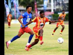 Credit: Ashley Anguin Cornwall College’s Marcane Gooden (front) dribbles the ball away from Kemps Hill High’s Orlando Campbell during their Group 1 football match in the second round of the ISSA daCosta Cup at Montego Bay Sports Complex on Saturday. Cornwall won 2-0.