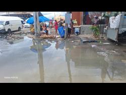 Vendors say that sewage at the corner of Rose Lane and Pechon Street in downtown Kingston is keeping customers away, as they try to earn some sales before the storm hits.