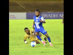 Credit: Antoine Lodge/Photographer Mount Pleasant Football Academy’s Demario Phillips dribbles away from Defence Force’s Kaihim Thomas during their Concacaf Caribbean Cup football match at the National Stadium in Kingston last night. Defence Force of Trinidad and Tobago won 1-0. Mount Pleasant FA won the tie 5-2 on aggregate, after winning the first leg 5-1 in Trinidad.