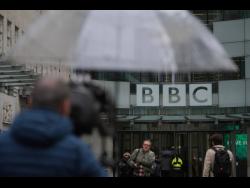 Credit: AP Photos Media members wait outside the BBC Headquarters in London on Monday.