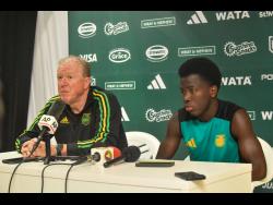 Steve McClaren (left) , head coach for the Reggae Boyz, speaks about his hopes and expectations for the team, while striker Kaheim Dixon looks on during the pre-game press conference at the National Stadium in Kingston yesterday. Jamaica will play against Curaçao in a Concacaf World Cup Qualifying football match today.