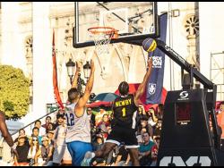 Jamaica’s Jabulani Newby (right) goes up for this layup in their match against the Dominican Republic.