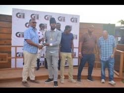 Connections of CALIFORNIA CROWN collect the winners’ trophy from Racing Secretary Denzil Miller (left) at Caymanas Park on Saturday.
