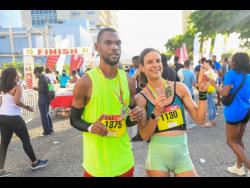 Garfield Gordon (left) and Cecile Heinrich pose after winning the respective men’s and women’s categories in the Reggae Half Marathon, downtown Kingston, yesterday.