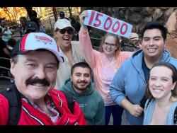 In this photo provided by Jon Alan Hale (left), he poses with friends after taking his 15,000th Radiator Springs Racers ride at Disney California Adventure in Anaheim,