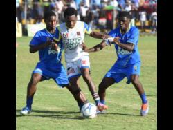 St. Elizabeth Technical High’s Deandre Barnett (centre) is challenged by Clarendon College’s Roshaun Sterling (left) and Chevon Richardson during their opening match of the ISSA daCosta Cup quarterfinals at STETHS Sports Complex  on Saturday, December 6, 2025.