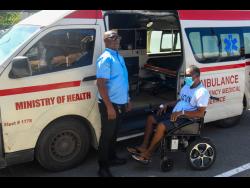 Credit: Matthew McKoy Kevin Henry (right) is escorted by ambulance to the Chinese medical ship, Silk Road Ark yesterday. The ship is docked in Port Royal.