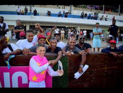 Jockey Javier Castellano, who rode Mouttet Mile winner RIDEALLDAY to victory, celebrates his big-race win with punters at Caymanas Park on Saturday. 
