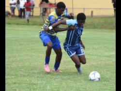 Manning’s School’s Jordan Turner (right) is challenged by Christiana High’s Darone Thomas (left) during the opening round of the ISSA Ben Francis Knockout quarterfinals at Manchester High playing field on Tuesday, December 16.