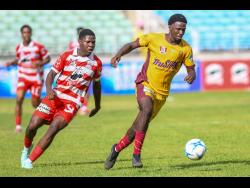 Orane Watson (left) of Glenmuir High School chases Orane Gayle of Dinthill Technical during the daCosta Cup football semi-final at Sabina Park in Kingston on Wednesday. Glenmuir won 2-1.