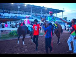 ANOTHER ONE (centre), with Dane Nelson aboard, celebrates with handlers on the racetrack after winning the Charles Hussey OD Trophy, an Overnight Allowance Stakes, over five furlongs straight at Caymanas Park on Saturday.