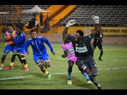 St Elizabeth Technical High School goalkeeper Johnoi Steadman is mobbed hounded by teammates after making the decisive penalty save to secure the 2025 ISSA WATA daCosta Cup title against Glenmuir High School in Saturday’s final at the National Stadium in Kingston.
